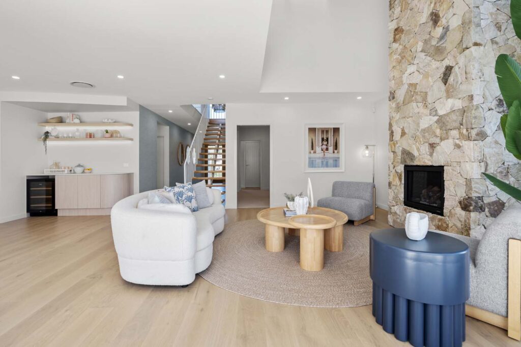 A living room with white furniture and stone walls.