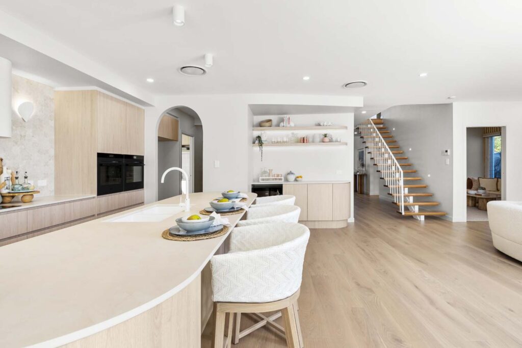 A kitchen with white walls and wooden floors.