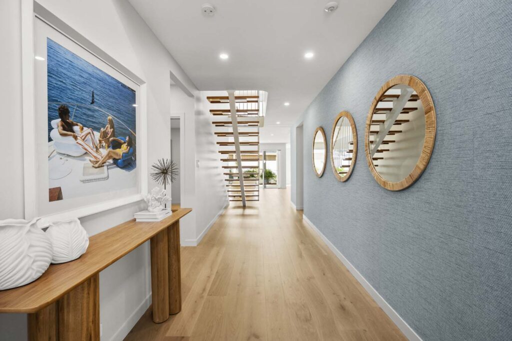 A hallway with two mirrors and a wooden table.